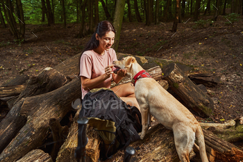 Happy sporty woman petting dog in forest / Photodune, Misc