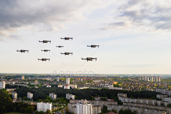 Drones fly over the city's houses. Urban landscape with drones flying over it, quadrocopters