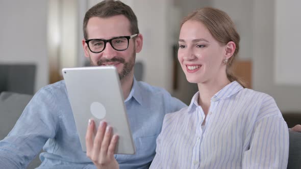 Portrait of Happy Young Couple Doing Video Call on Tablet