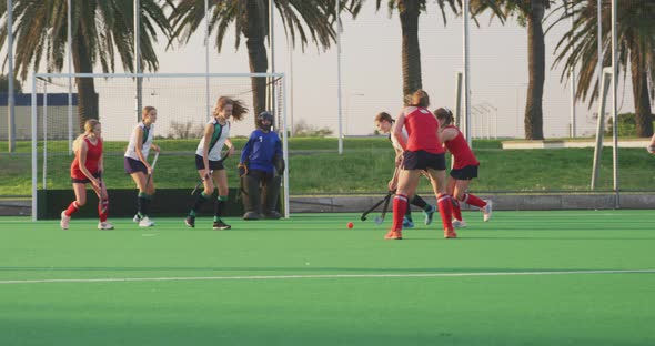 Female hockey players playing on the field