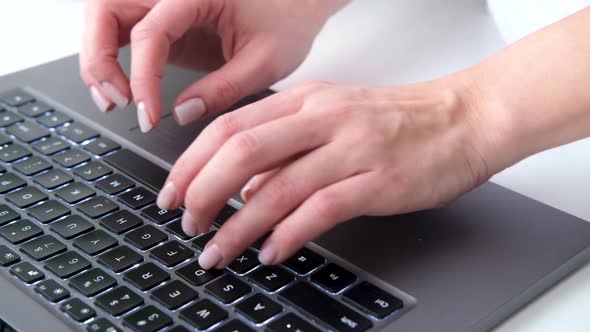 Closeup of Female Hands Typing on Keyboard Notebook Computer