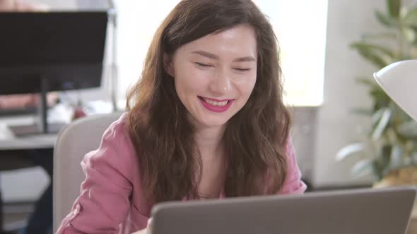 Young Beautiful Brunette Works on a Laptop Computer in Cool Creative Agency in a Loft Office