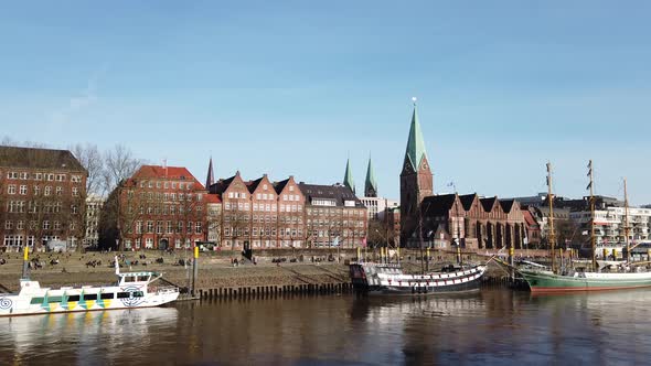 Pan along Bremen Weser promenade Schlachte with ships and view of St. Martini church and Teerhof bri