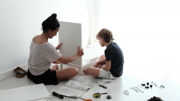 Mother and kid assembling furniture at home