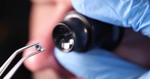 Gloved Technician Holds Magnifying Glass and Tweezers and Looks at Gem  Movie