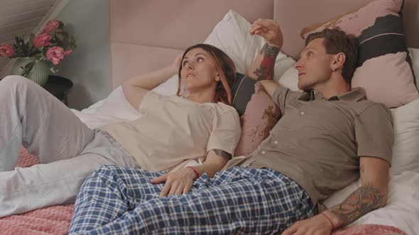 Woman and Man Relaxing in Bed
