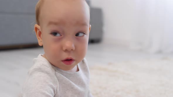 Caucasian Baby Turning Around and Looking Attentively at Something