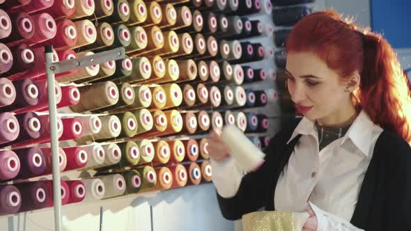 Happy Seamstress Choosing a Colour of Thread Reel in Atelier