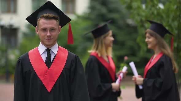 Graduation Ceremony, Happy Man in Academic Dress Looking Into Camera, Laughing
