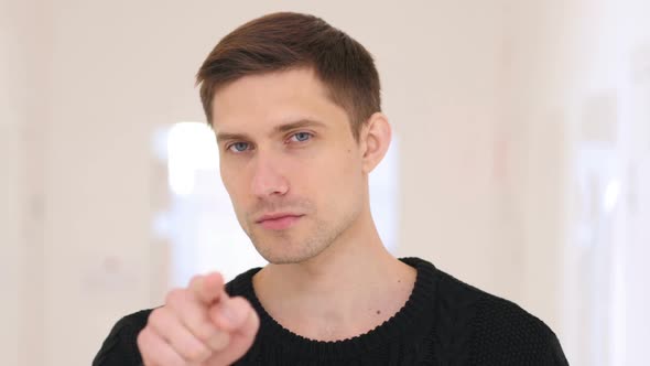 Portrait of Man Pointing at Camera Sitting in Office