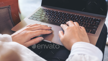 Closeup image of a woman's hands working and typing on laptop keyboard on table / Photodune, Misc