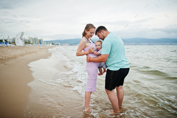 Father, pregnant mother, baby daughter on sea sand beach. / Photodune, Misc