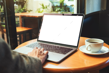 a woman using and touching on laptop touchpad with blank white desktop screen with coffee cup / Photodune, Misc