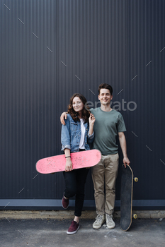Modern smiling pair standing together with skateboards / Photodune, Misc