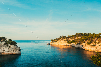 of Calanques on the azure coast of France. Calanques – a deep bay surrounded by high cliffs. Landscape in sunrise light during Sunny summer morning.