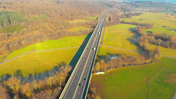 drone flight over a highway bridge with cars and trucks panorama view