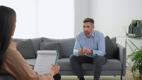 Emotional Adult Man Patient with Mental Health Problems Talking to Therapist