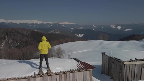 The Traveler Watches the Mountain Landscape Standing on the Roof of a Building in the Mountains