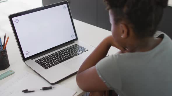 Happy african american girl using laptop with copy space