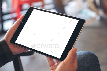Mockup image of woman's hands holding black tablet pc with blank screen horizontally in cafe / Photodune, Misc