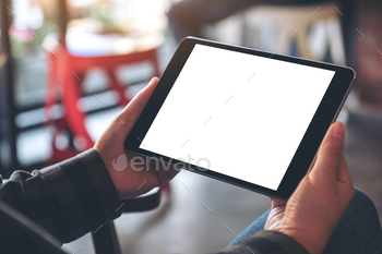 Mockup image of woman's hands holding black tablet pc with blank screen horizontally in cafe / Photodune, Misc