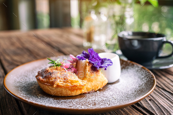 A piece of coconut pie with a beautiful decoration and a cup of coffee on wooden table / Photodune, Misc