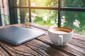 A single laptop computer with a coffee cup on wooden table / Photodune, Misc
