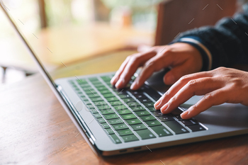 Closeup image of hands using and typing on laptop computer keyboard on the table / Photodune, Misc