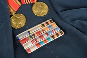 closeup shot of different medals on navy blue jacket, victory day concept / Photodune, Misc