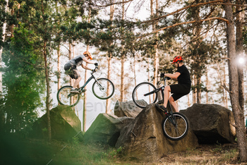 trial bikers performing stunts on rocks outdoors / Photodune, Misc