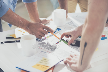 cropped shot of businessmen pointing at diagrams and working on new project at office / Photodune, Misc
