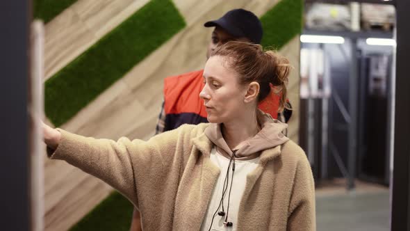 Shop Assistant Helps the Woman to Choose New Wooden Laminate