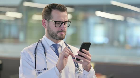 Portrait of Young Male Doctor Using Smartphone