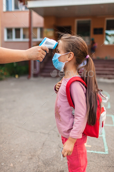 Back to school. Teacher measuring temperature with non-contact thermometer / Photodune, Misc