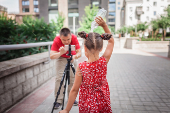 Make money online. Father recording film with daughter for family channel, video blogger / Photodune, Misc