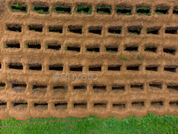 Open empty graves among the green lawn, aerial drone view of emty tombs. / Photodune, Misc