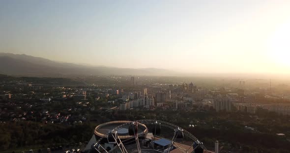 Ferris wheel at sunset overlooking the city and mountains