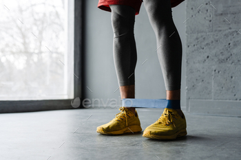 White sportsman doing exercise with expander stretch tape indoors / Photodune, Misc