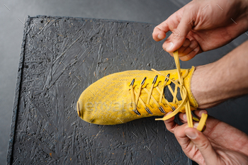 Young sportsman tying his shoe laces while working out / Photodune, Misc
