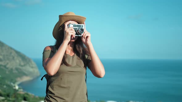 Female Professional Photographer Taking Picture Using Vintage Film Camera on Peak of Mountain