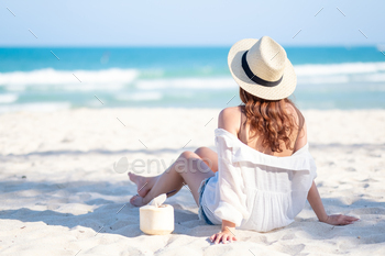 Portrait image of a beautiful asian woman enjoy sitting and drinking coconut juice on the beach / Photodune, Misc