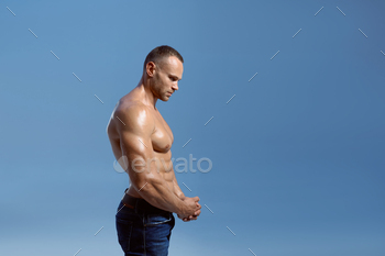Male athlete shows his biceps in studio, side view / Photodune, Misc