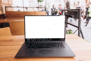 White laptop screen on the table in a cafe on the street / Photodune, Misc