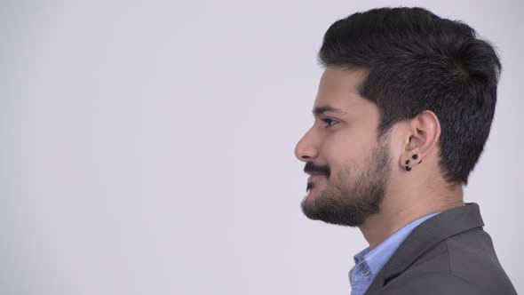 Profile View of Young Happy Bearded Indian Businessman Smiling
