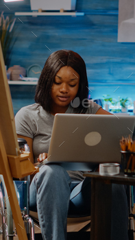 Black artist with handicap typing on laptop computer / Photodune, Misc