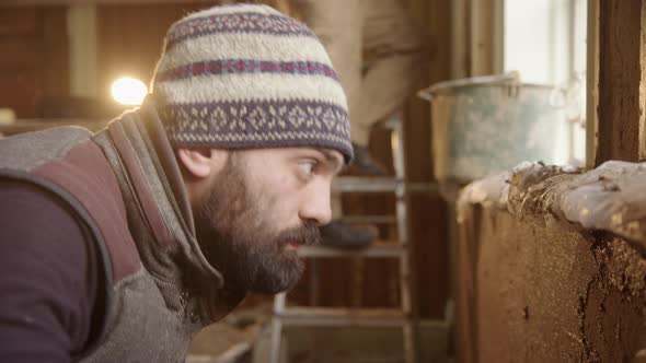 An Asian man rendering with clay as he does up his house