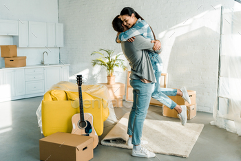happy husband hugging wife while packing for new house, moving concept / Photodune, Misc