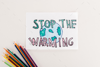 card with earth symbol and"stop warming" inscription, and multicolored pencils on white background / Photodune, Misc