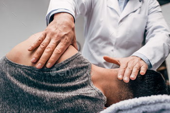 chiropractor in white coat massaging neck of man / Photodune, Misc