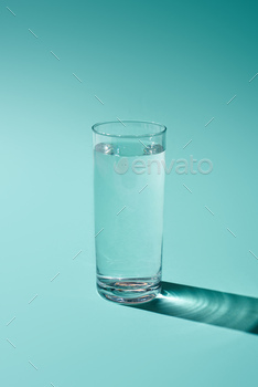 transparent glass with water on turquoise background / Photodune, Misc
